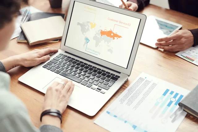 Professional team discussing global marketing strategies with charts and graphs on a laptop. How to choose a primary market research agency